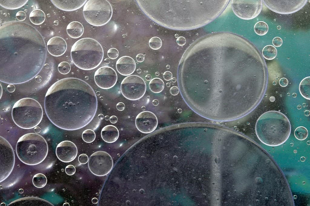 Abstract fluid droplets in teal and violet